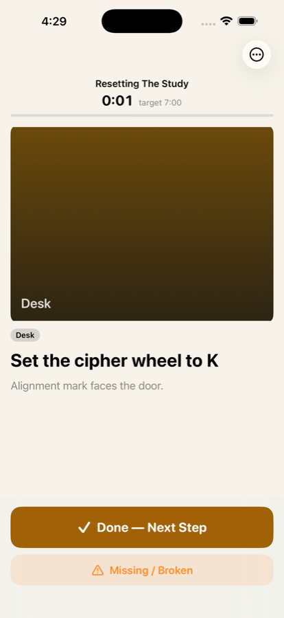 A reset in progress: the timer reads 0:01 against a 7:00 target, above a reference photo of a desk and the step Set the cipher wheel to K.